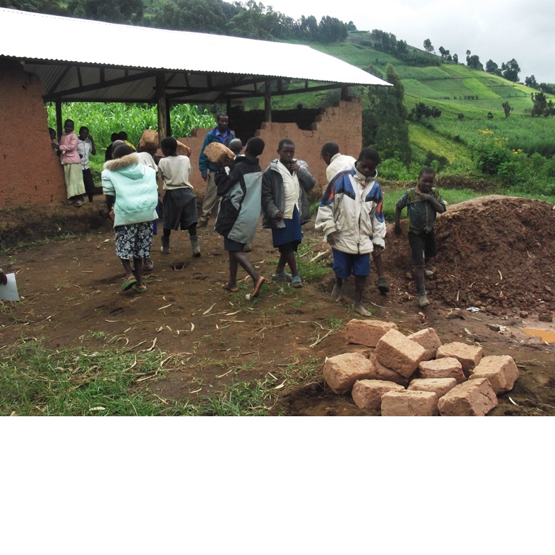 Pupils at Bikaniro beside adobe bricks laid out to dry
